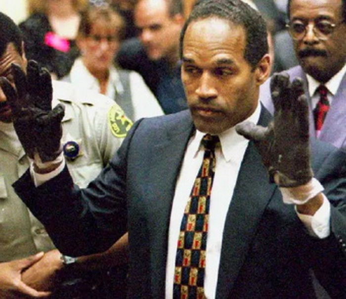 OJ Simpson trying on a pair of glovesl